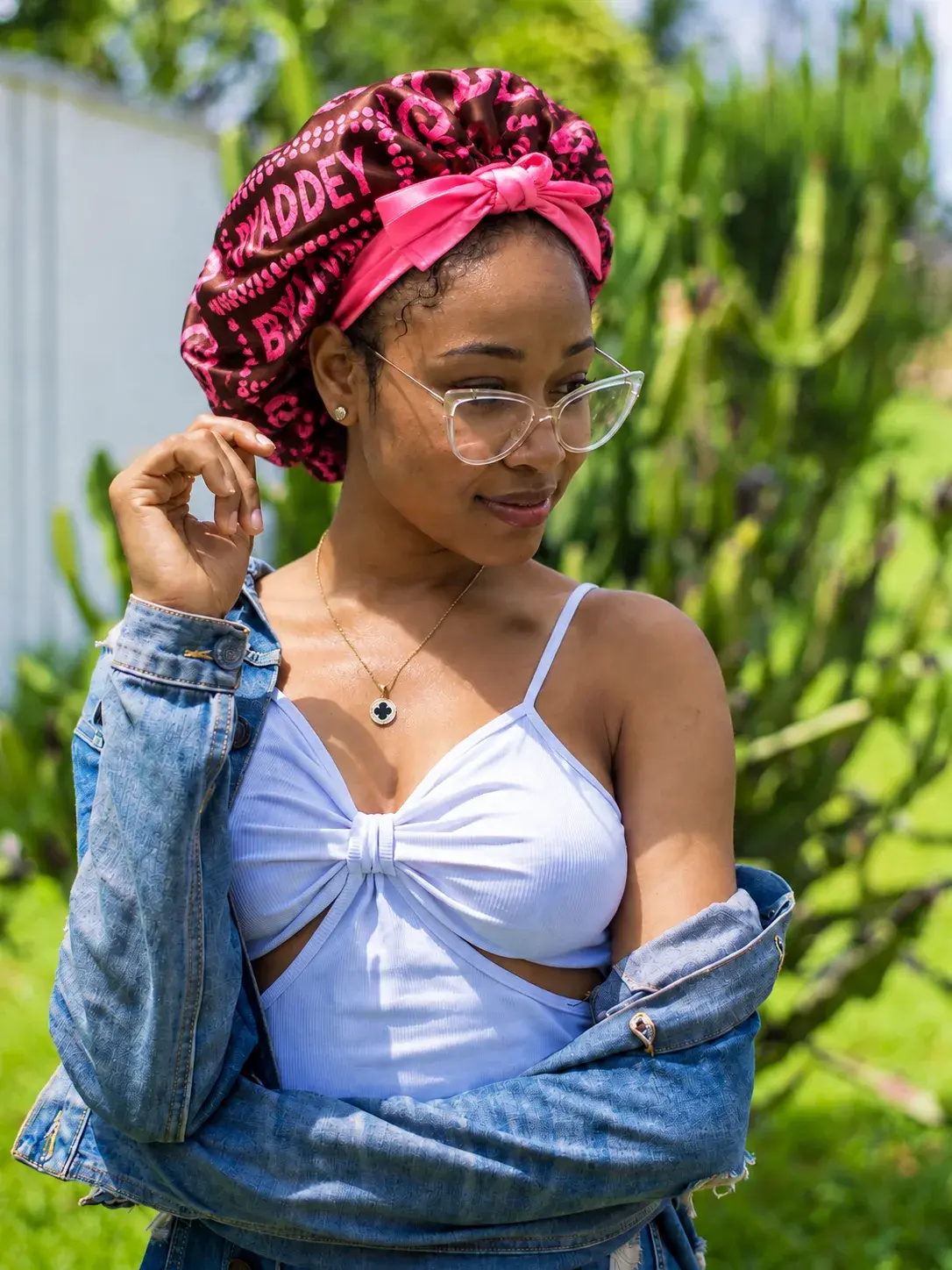Wearing the Adé Bonnet in Berry in a sunny garden